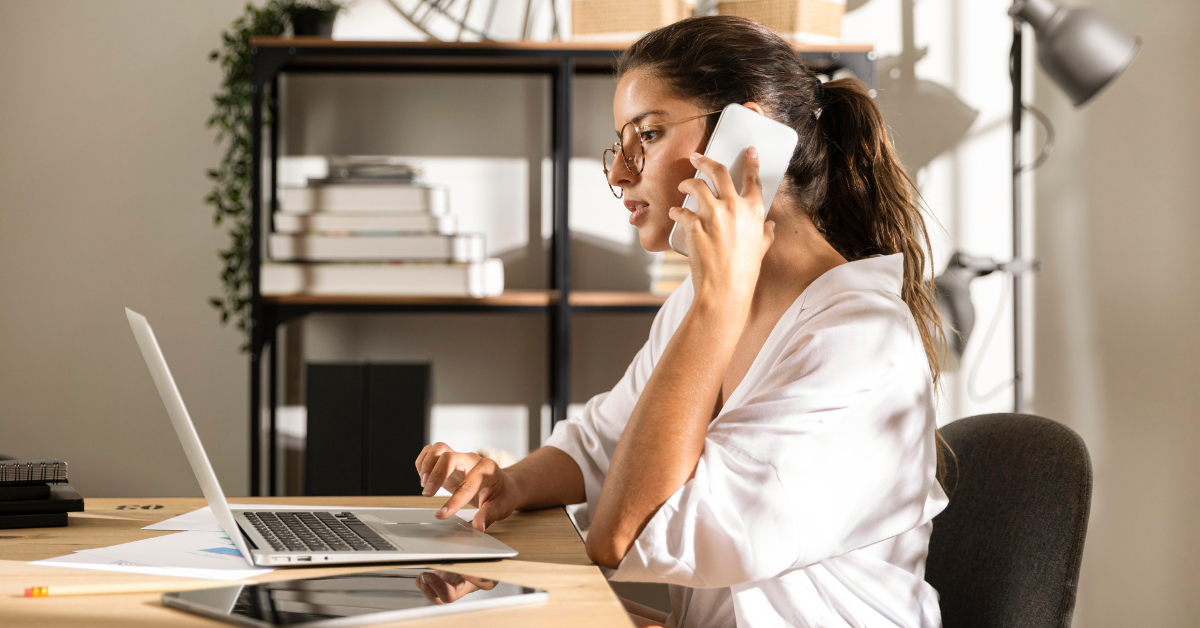 woman Latam engineer sitting table talking at the phone